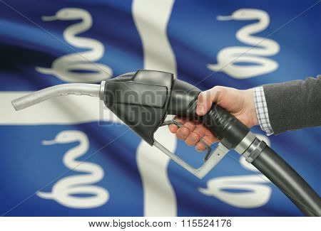 Fuel Pump Nozzle In Hand With National Flag On Background - Martinique