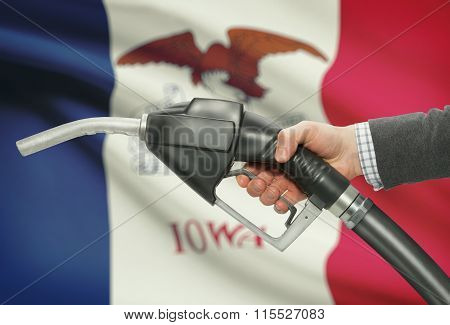 Fuel Pump Nozzle In Hand With Usa States Flags On Background - Iowa