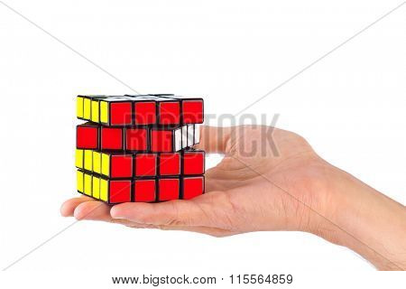 MOSCOW, RUSSIA - August 31, 2014: Hands and Rubik's cube puzzle isolated on the white background. Cube was invented by a Hungarian architect Erno Rubik in 1974.