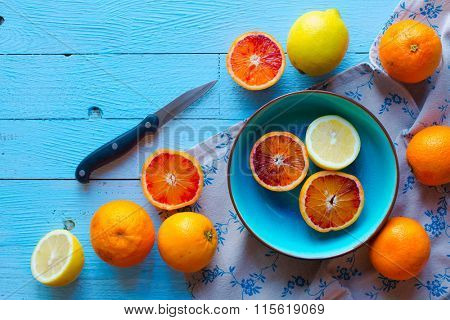 Colorful Orange fruits over a light blue painted wood table with a simmetric position.