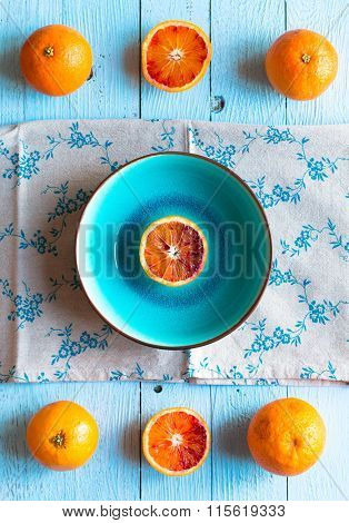 Colorful Orange fruits over a light blue painted wood table with a simmetric position.