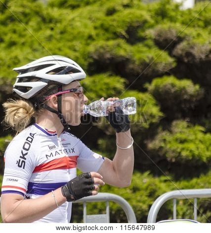 A woman drinking water on a cycle race