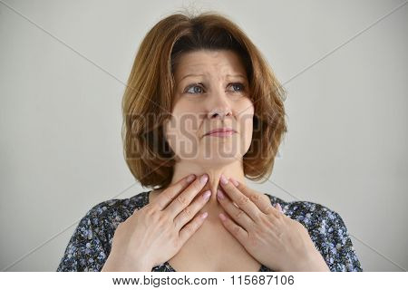 Adult woman with a sore throat on  light background