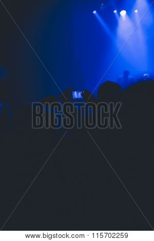 Concert Goer Taking Photos With Mobile Of Rock Band.