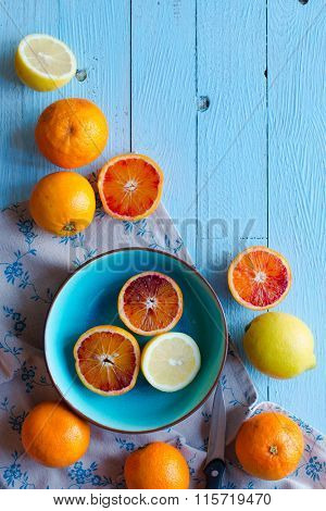 Colorful Orange fruits over a light blue painted wood table with a simmetric position.