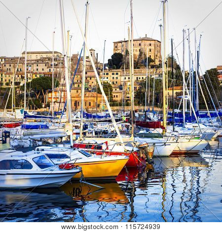 sunset on lake Bolsena, view with sailng boats and village Capod