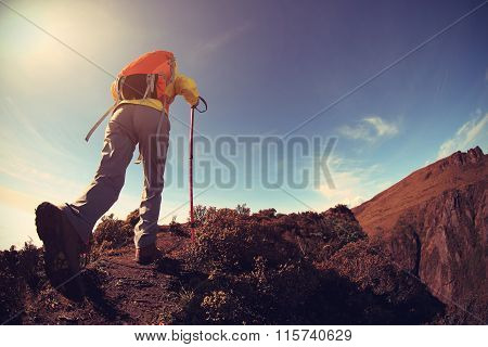 one young woman backpacker hiking on mountainpeak