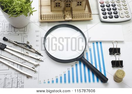 Model house, construction plan for house building, magnifying glass, divider compass. calculator. Re
