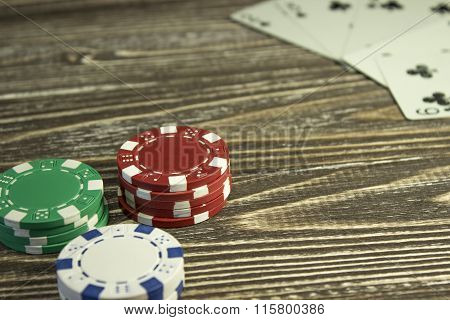 Poker Chips And Playing Cards On The Table. Focus On Red Chips