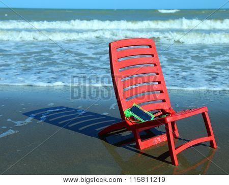 Chair On The Beach With A Smartphone Closed In The Protective Wa