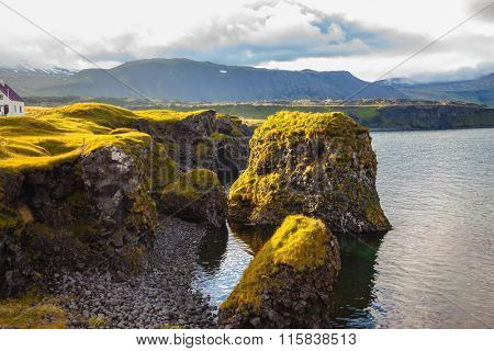 Quiet summer evening on the coast of Iceland. Sunset in the fishing village of Arnastapi
