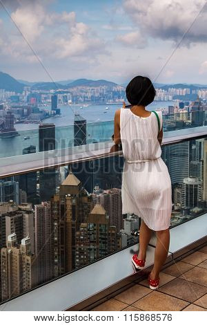 A girl is looking at Hong Kong from Victoria peak