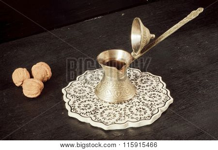 Cooper Turkish Cezve With Black Coffee On Patterned Ceramic Tray And Walnuts