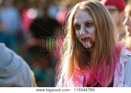 Woman Wearing Zombie Makeup Wanders Through Crowd At Halloween Festival