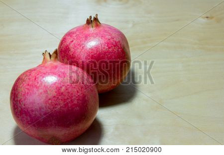 large red pomegranates on wooden background with selective focus