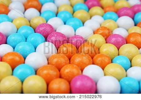 Shiny sugar coated round chocolate balls as background. Candy bonbons multicolored texture. Round candies sweets pattern concept. Food photo studio photography. Candy background. Texture background.