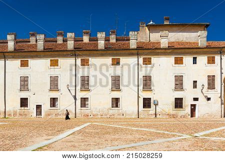 Mantua (Mantova) - July 2017, Italy: Lonely woman walking along The Castle Square (Piazza Castello) in Mantua