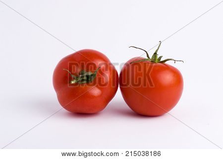 Fresh tomatoes isolated on white background. Two red ripe tomatoes isolated on white background. Tomatoes on white background.