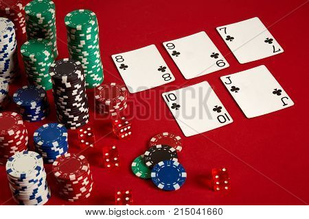 Casino gambling poker equipment and entertainment concept - close up of playing cards and chips at red background. Straight Flush. Casino background. Copy space. Still life