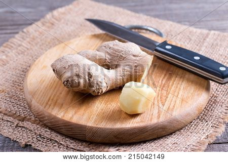 A piece of ginger on a wooden cutting board