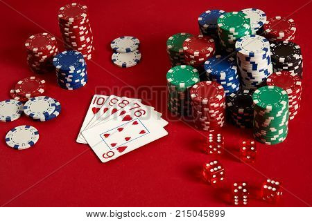 Casino gambling poker equipment and entertainment concept - close up of playing cards and chips at red background. Straight Flush. Casino background. Copy space. Still life