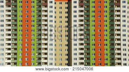 The facade of a typical block multi-storey residential building. Front view close up.