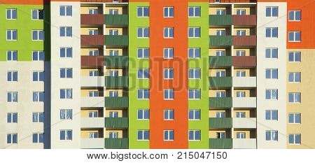 The facade of a typical block multi-storey residential building. Front view close up.