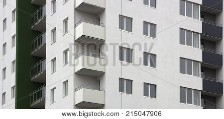 The facade of a typical block multi-storey residential building. Front view close up.