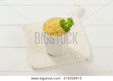 cup of uncooked alphabet pasta on white table mat