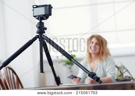 Photo of woman blogger at atable with florarium.