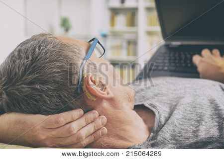 Hearing impaired man using laptop in home