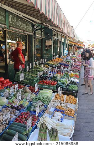 VIENNA AUSTRIA - JULY 11 2015: Tourists Shopping at Naschmarkt Farmers Market in Vienna Austria.