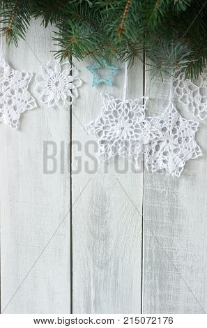 Christmas Or New Year Background With Fir Branches And Knitted White Snowflakes On A White Backgroun