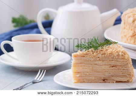 Round multi-layered cake Napoleon with custard on a light-blue table background. Selective focus. Toned.