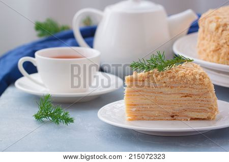 Round multi-layered cake Napoleon with custard on a light-blue table background. Selective focus. Toned.