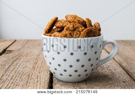 Chocolate cookies in coffee cup on the wooden table.