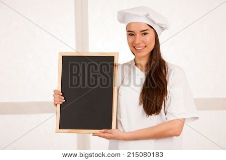 Young Blonde Chef Woamn Holds Kitchenware As She Prepares To Cook A Meal Isolated Over White Backgro