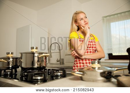 Beautiful Young Woman In Kitchen Thinks Waht To Cook For Meal