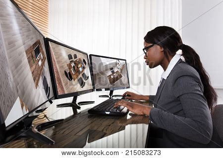 African Businesswoman Wearing Eyeglasses Checking Security Camera On Multiple Computers