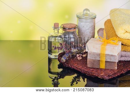 Spa products for facial and body care. Natural sea salt homemade soap massage oil and colorful towels. Spa and bodycare concept.