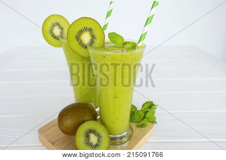 Kiwi Yogurt Healthy Fruit Smoothie Drink in the morning on a white wood background.