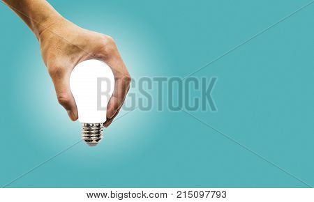 hand holding glowing polygonal lamp on background blue. Innovative ideas concept. Bright idea. the way to solve problem. business. Creative thinking Bright Ideas for Business Finance Solutions.