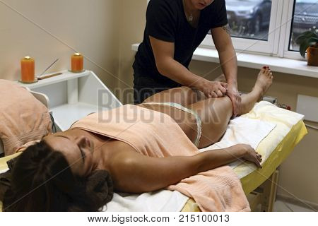 Brunette Fit Woman Client Receiving Body Massage At Spa Club By Tattooed Massagist. Top View