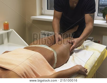 Brunette Fit Woman Client Receiving Body Massage At Spa Club By Tattooed Massagist. Top View