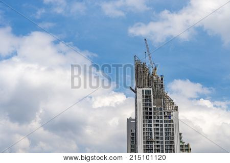 Crane working on high building with sky