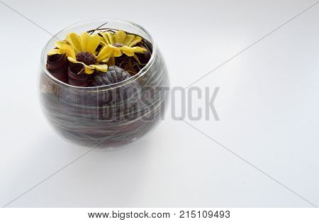 A small glass vase with yellow dots on a white background.