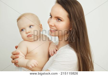Baby in mother's hand. Little enfant toddler, lovely son or daughter with blonde hair and blue eyes.