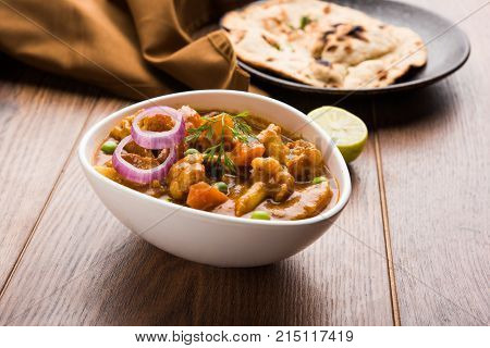 Aloo Gobi matar is a famous Indian curry dish with potatoes and cauliflower and green peas, selective focus