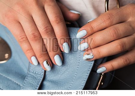 Beautiful manicure. Gel polish coating in blue, embossing.