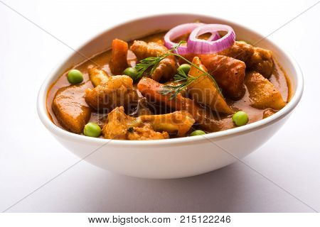 Aloo Gobi matar is a famous Indian curry dish with potatoes and cauliflower and green peas, selective focus